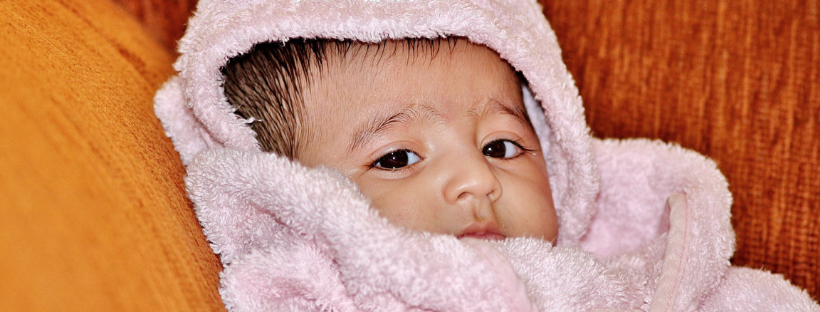 Baby nach dem Baden in Handtuch eingewickelt